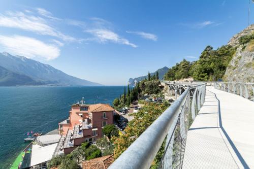 a bridge over the water with buildings on the side of a mountain at Hotel Capo Reamol in Limone sul Garda