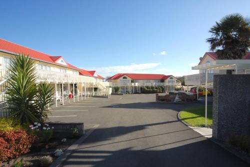 a street in a town with houses and palm trees at BK's Fountain Court Motel in Napier