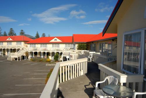 a row of buildings with red roofs in a parking lot at BK's Fountain Court Motel in Napier