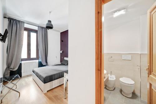 um quarto com uma cama e um WC num quarto em Peroni 8 Pax Brand New Apartment em Roma