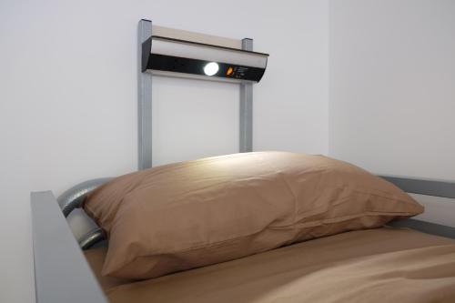 una almohada sobre una cama con reloj en Black Isle Hostel, en Inverness