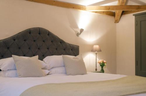 a bedroom with a large white bed with a black headboard at Retreat East in Ipswich
