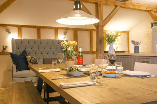 a dining room table with wine glasses and a light fixture at Retreat East in Ipswich
