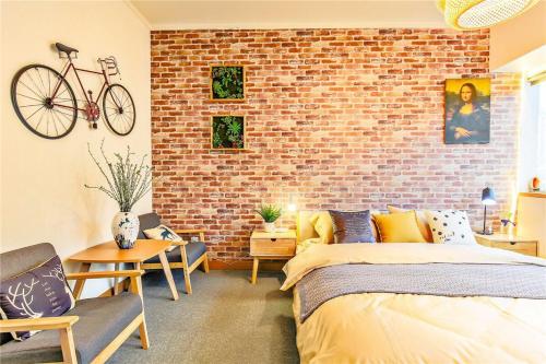 a bedroom with a bed and a brick wall at Hangzhou Xihu District ·Huanglong Sports Center Locals Apartment 00147450 in Hangzhou