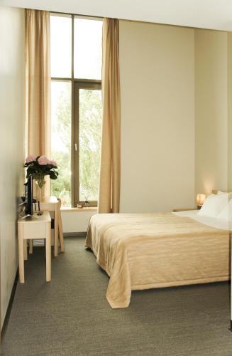 ein Schlafzimmer mit großem Bett und Fenster in der Unterkunft Zaliasis slenis - Self check-in hotel - Free parking in Klaipėda