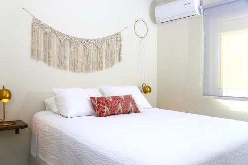 una camera da letto con un letto con lenzuola bianche e una finestra di Casa Alessandra 2bdr a Palm Beach