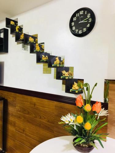 a clock and a vase with flowers on a table at Condotel in Baguio