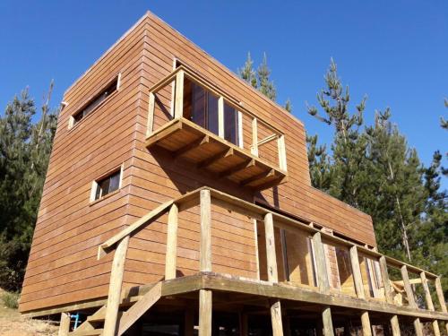 a house built on top of a wooden structure at Acuarela minicasas con piscina en Lago Vichuquen in Vichuquén