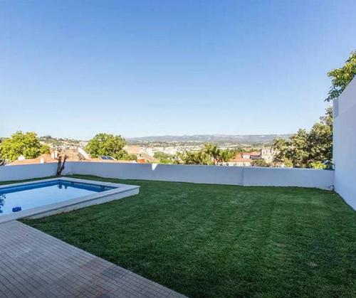 a backyard with a swimming pool and green grass at Stunning view Alcobaça in Alcobaça