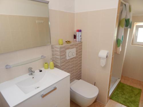 ein Badezimmer mit einem weißen Waschbecken und einer Toilette in der Unterkunft Apartmani Nin in Nin