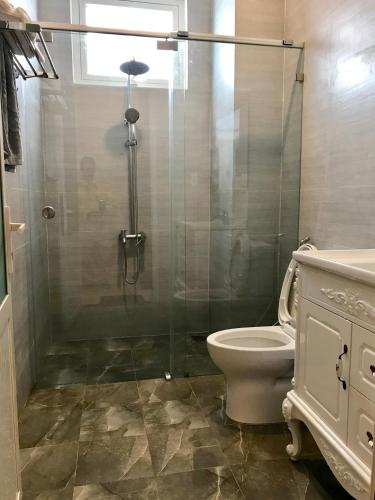 a bathroom with a toilet and a glass shower at Villa Hotel Thao Nguyen in Da Lat