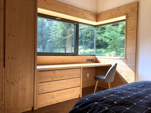sypialnia z łóżkiem, biurkiem i oknem w obiekcie Chalet Slovensky Raj w mieście Smižany