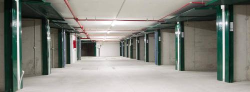 an empty hallway in a building with green columns and ceilings at Hotel San Lorenzo in Bormio