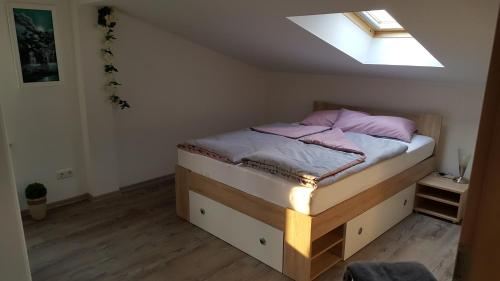 ein kleines Schlafzimmer mit einem Bett und einem Dachfenster in der Unterkunft Ferienwohnung "Burgblick" in Heldrungen