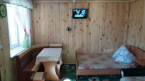 マンジェロクにあるApartments on river Katun`のベッド、テーブル、テレビが備わる客室です。