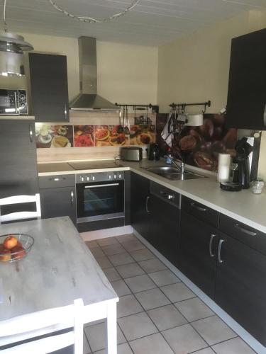 a kitchen with black cabinets and a counter top at Kleine Auszeit in Neunkirchen