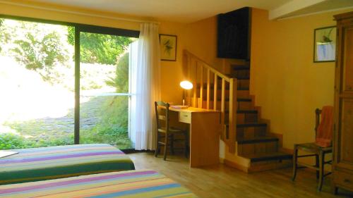 a room with a bed and a staircase with a table at Maison La Luzienne - Lou Astiou in Luz-Saint-Sauveur