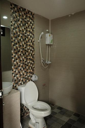 a bathroom with a toilet and a shower at Puangpech Hotel Lampang in Lampang