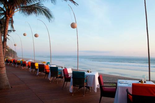 a row of tables and chairs on the beach at The Samaya Seminyak Bali in Seminyak