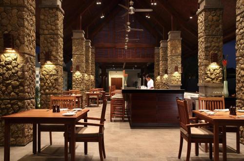 a restaurant with wooden tables and a chef in the kitchen at The Samaya Seminyak Bali in Seminyak