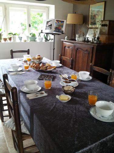 Saint-AugustinにあるCouleurs et jardinの食べ物とオレンジジュースが入ったテーブル
