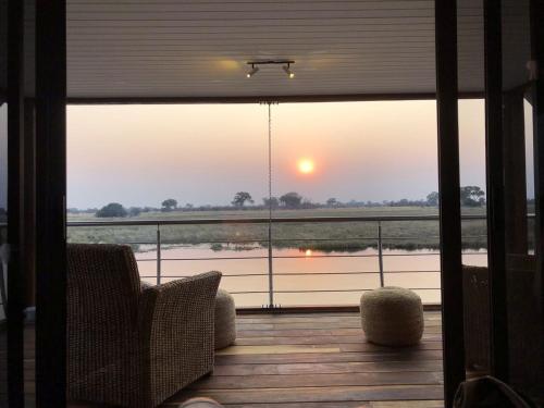 a room with a balcony with a view of a river at The Namushasha River Villa in Kongola