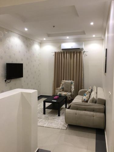 a living room with a couch and a tv at Dior Inn Apartment Hotel in Jeddah