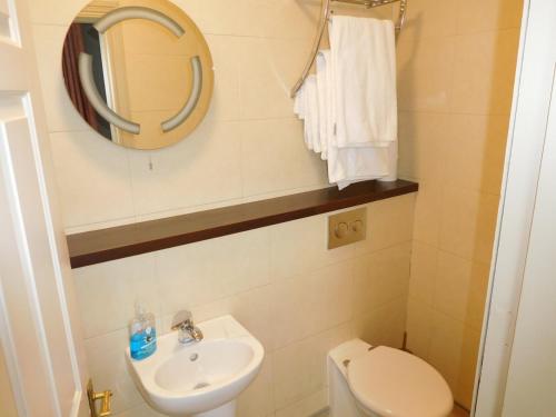 een badkamer met een wastafel, een toilet en een spiegel bij Anam Cara B&B in Cork