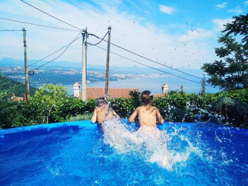 zwei Personen sitzen in einem Pool mit Wasser in der Unterkunft Apartment Mare in Opatija
