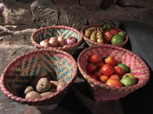 vier Körbe mit verschiedenen Obst- und Gemüsearten in der Unterkunft River Edge Resort Nepal in Benighāt