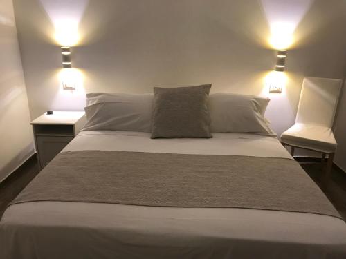a bedroom with a large bed with two lights at Hotel Cambogia in Zibido San Giacomo