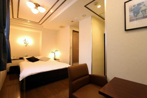a hotel room with a bed and a chair at Hotel 3 O'Clock Tennoji in Osaka