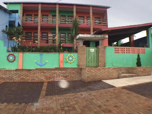 un bâtiment avec une clôture en briques devant lui dans l'établissement POUSADA MARINA PRAiA, à Beberibe