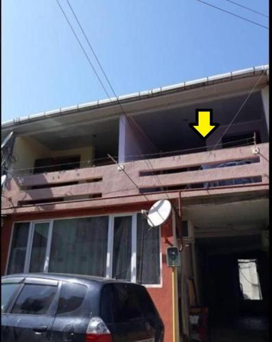 una macchina parcheggiata di fronte a una casa con una freccia gialla di FLAT1 a Ureki
