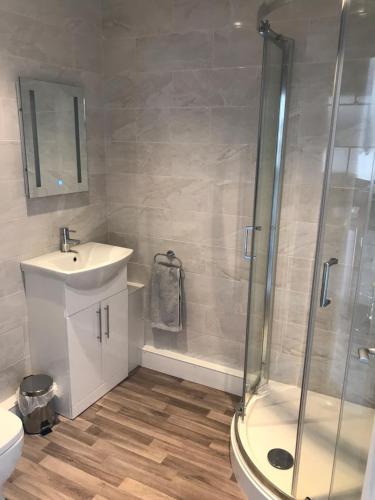 a bathroom with a shower and a sink and a toilet at Fornham Guest House in Chertsey