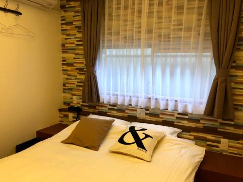 a bedroom with a white bed with a window at Hotel 3 O'Clock Tennoji in Osaka