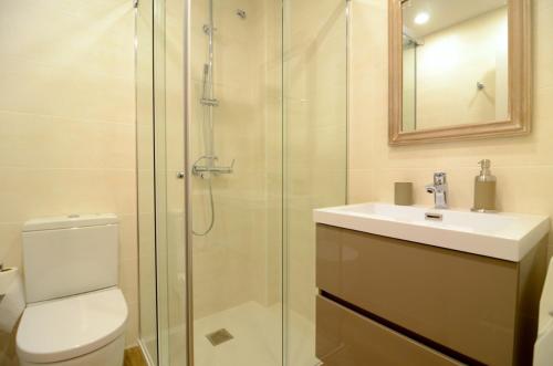 a bathroom with a shower and a toilet and a sink at Golf Mar II G 1-2 in Pals