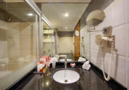 a bathroom with a sink and a mirror at Al Safwah Orchid Hotel in Makkah
