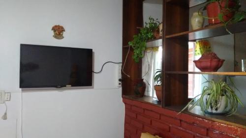 sala de estar con TV en una pared de ladrillo en El Encuentro en Juana Koslay 
