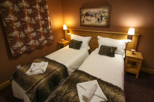 two beds in a hotel room with towels on them at Time to Ski - La Niche in Sainte-Foy-Tarentaise