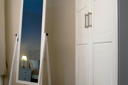 a white door with a mirror in a bedroom at Xenía B&B in Piazza Armerina