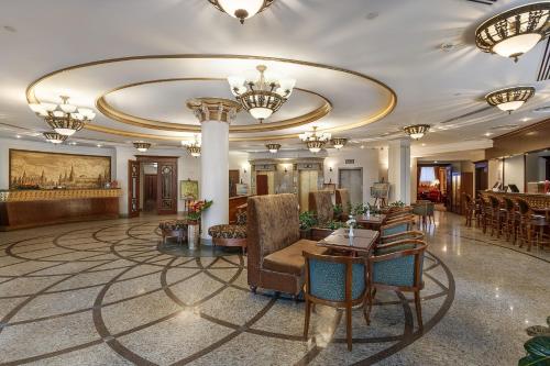 a lobby of a hotel with chairs and tables and chandeliers at Hotel Garden Ring in Moscow