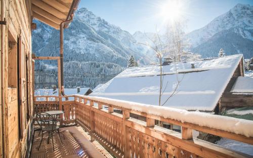 a balcony of a house with a snow covered roof at Lifestyle Rooms & Suites by Beau-Séjour in Champéry
