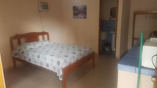 Cama pequeña en habitación con suelo azul en Sunrise Inn, en Puerto Armuelles