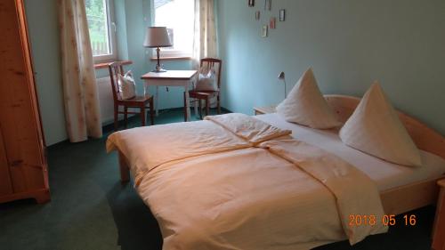 a bedroom with a bed with pillows and a table at Ferienwohnung Weitermann in Berg