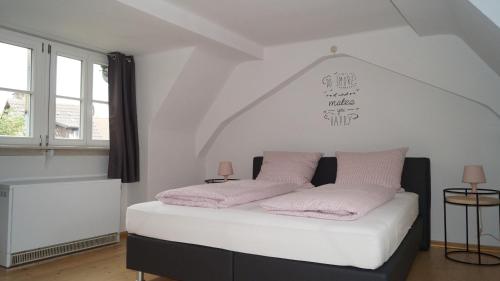 シュタウフェン・イム・ブライスガウにあるFerienwohnung im historischen Stadttorのベッドルーム1室(ピンクの枕2つ付)