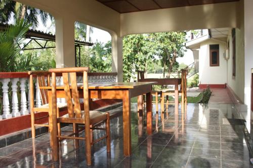a wooden table and chairs on a porch at Sunshine Tourist Rest in Anuradhapura