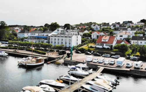 a group of boats docked at a dock in a harbor at Grand Hotel Åsgårdstrand - Unike Hoteller in Åsgårdstrand