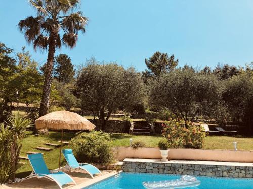 twee stoelen en een parasol naast een zwembad bij Maison de vacances Villa Cardabella in Le Tignet