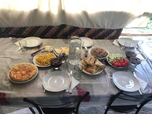 a table with plates and bowls of food on it at Pirikiti in Akhmety